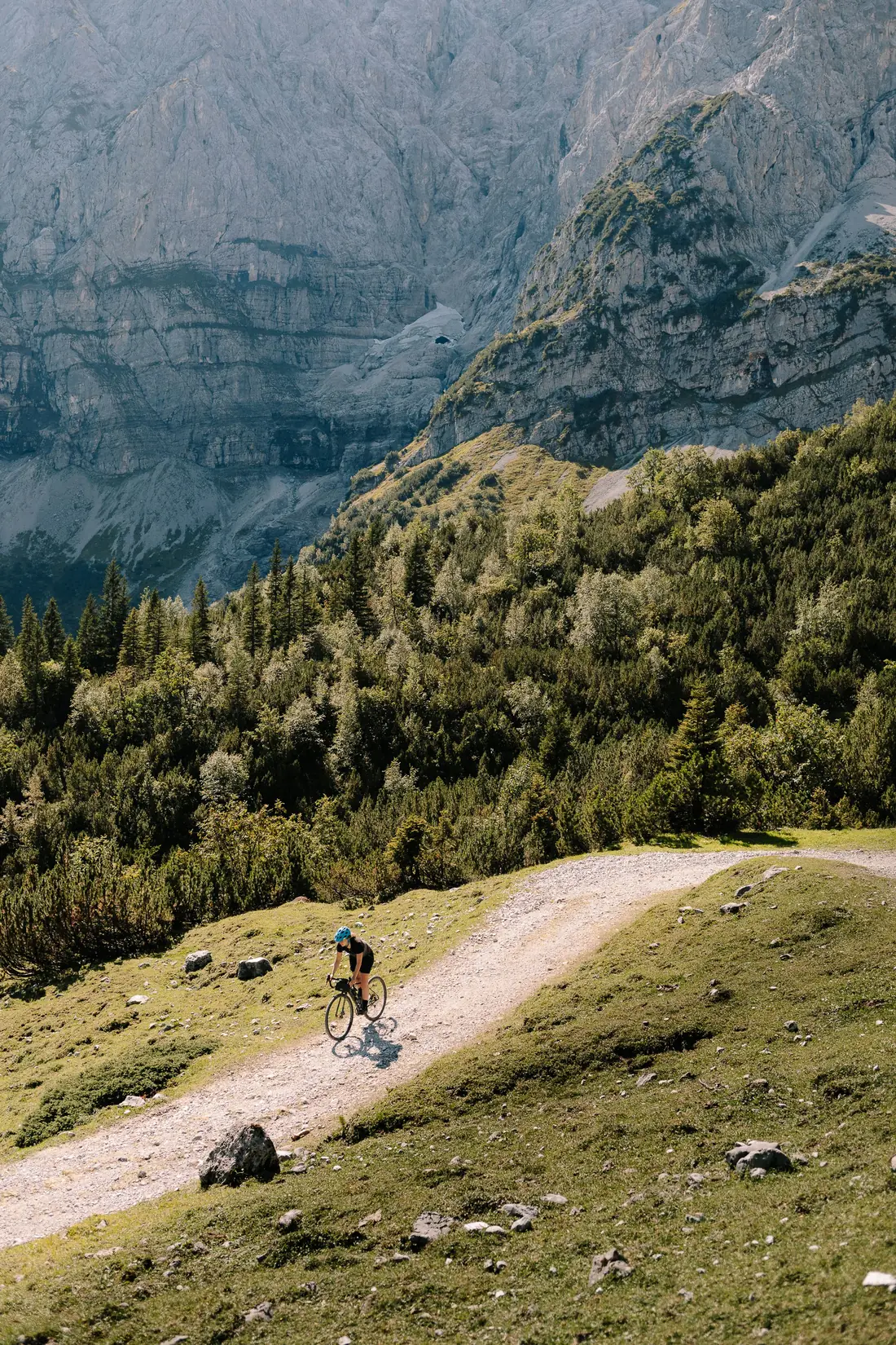 Un coureur seul sur une route de montagne, sous les falaises.